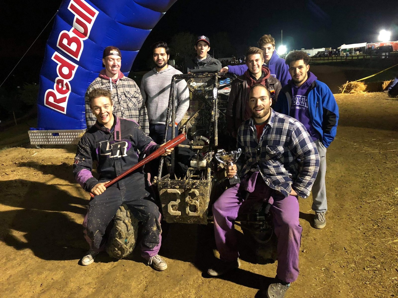 Western Baja SAE team with the car under the Red Bull arch at night