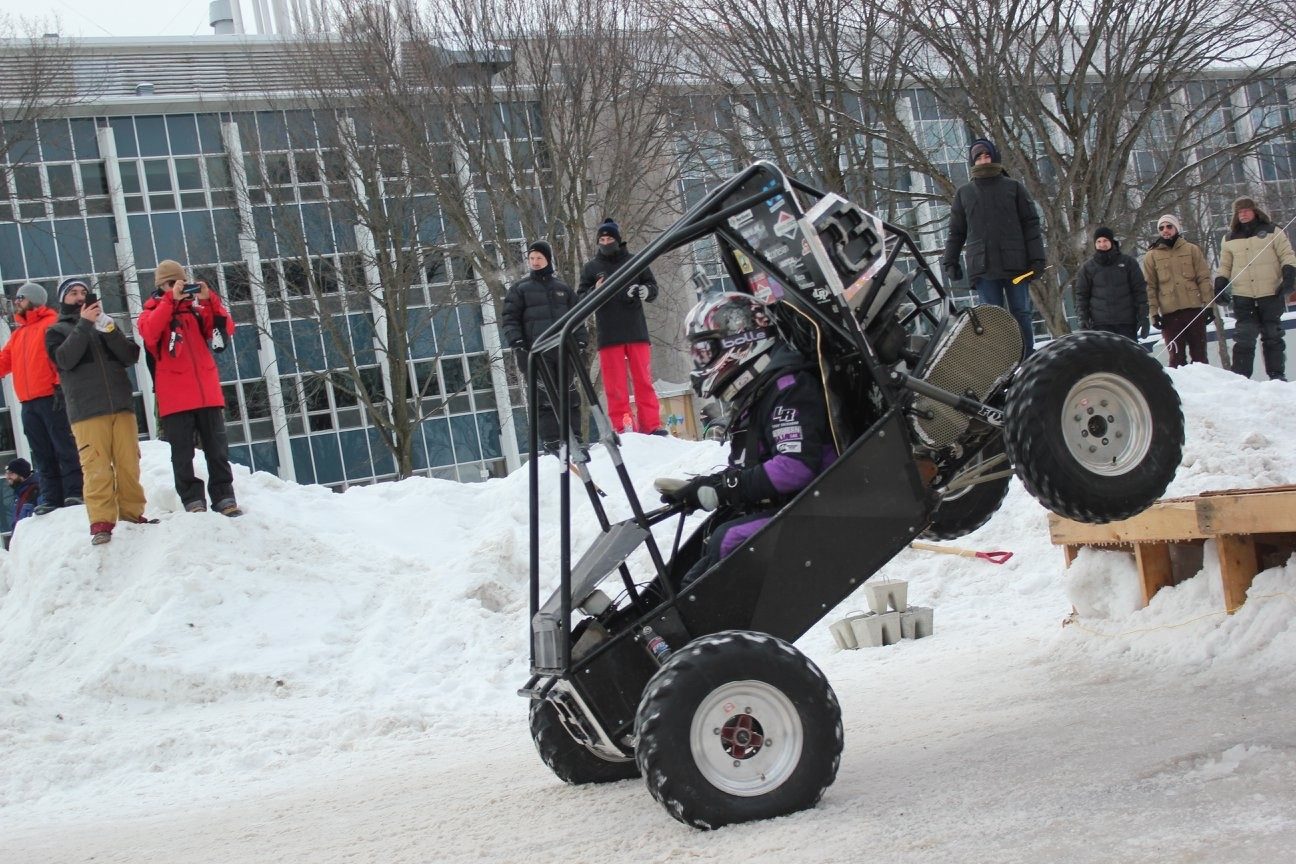 Western Baja SAE race car launching off a snow ramp at a winter competition